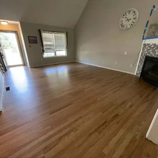A living room with hardwood floors and a ceiling fan.