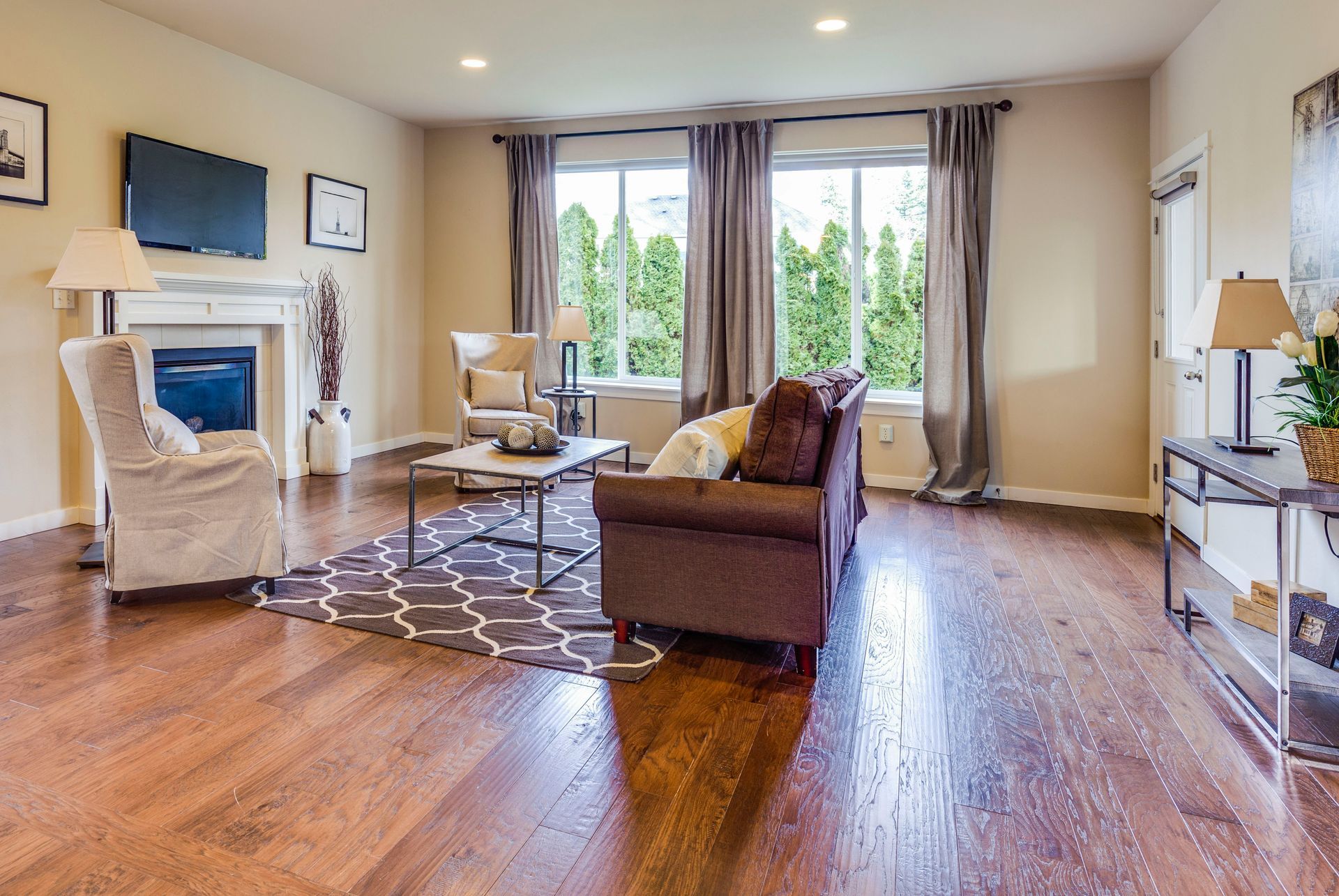 A living room with hardwood floors and stairs in a house.