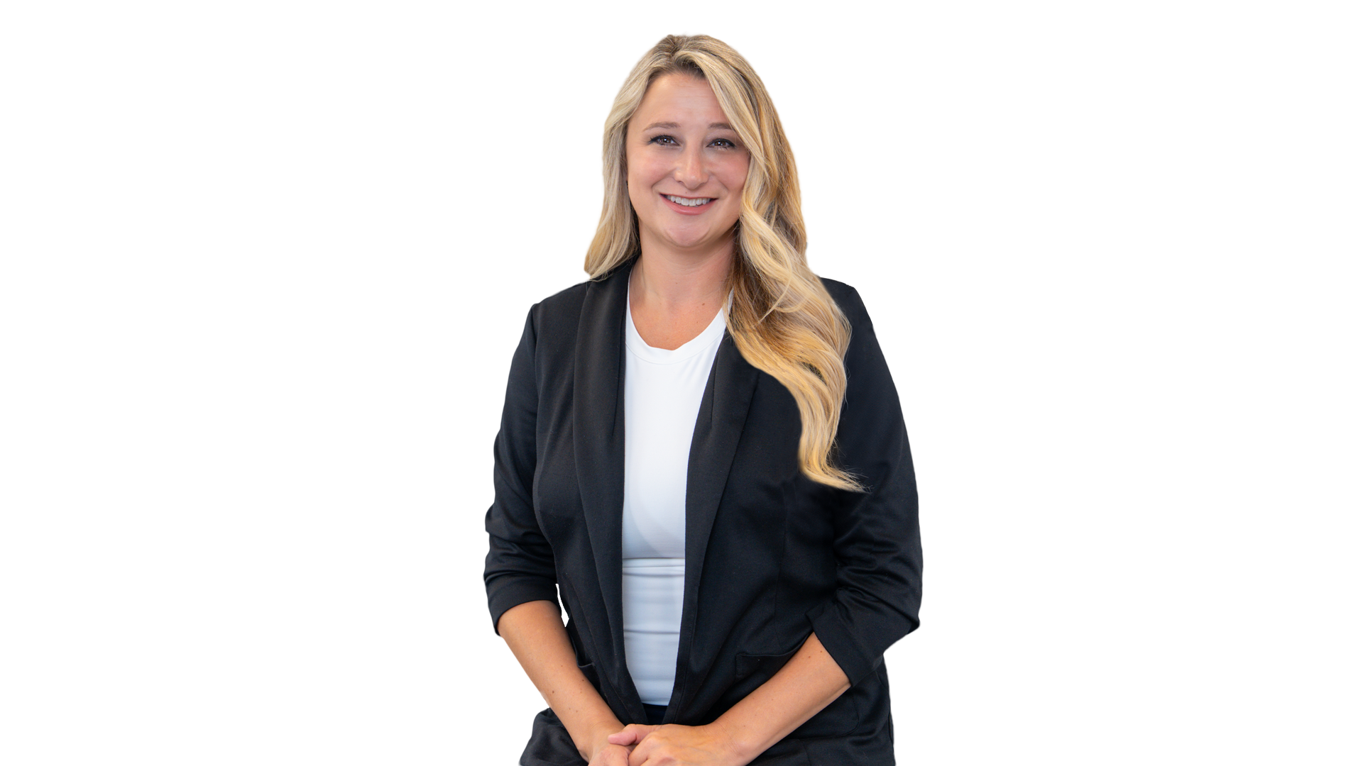 Blonde woman smiling with arms crossed, wearing a black blazer over a white top.
