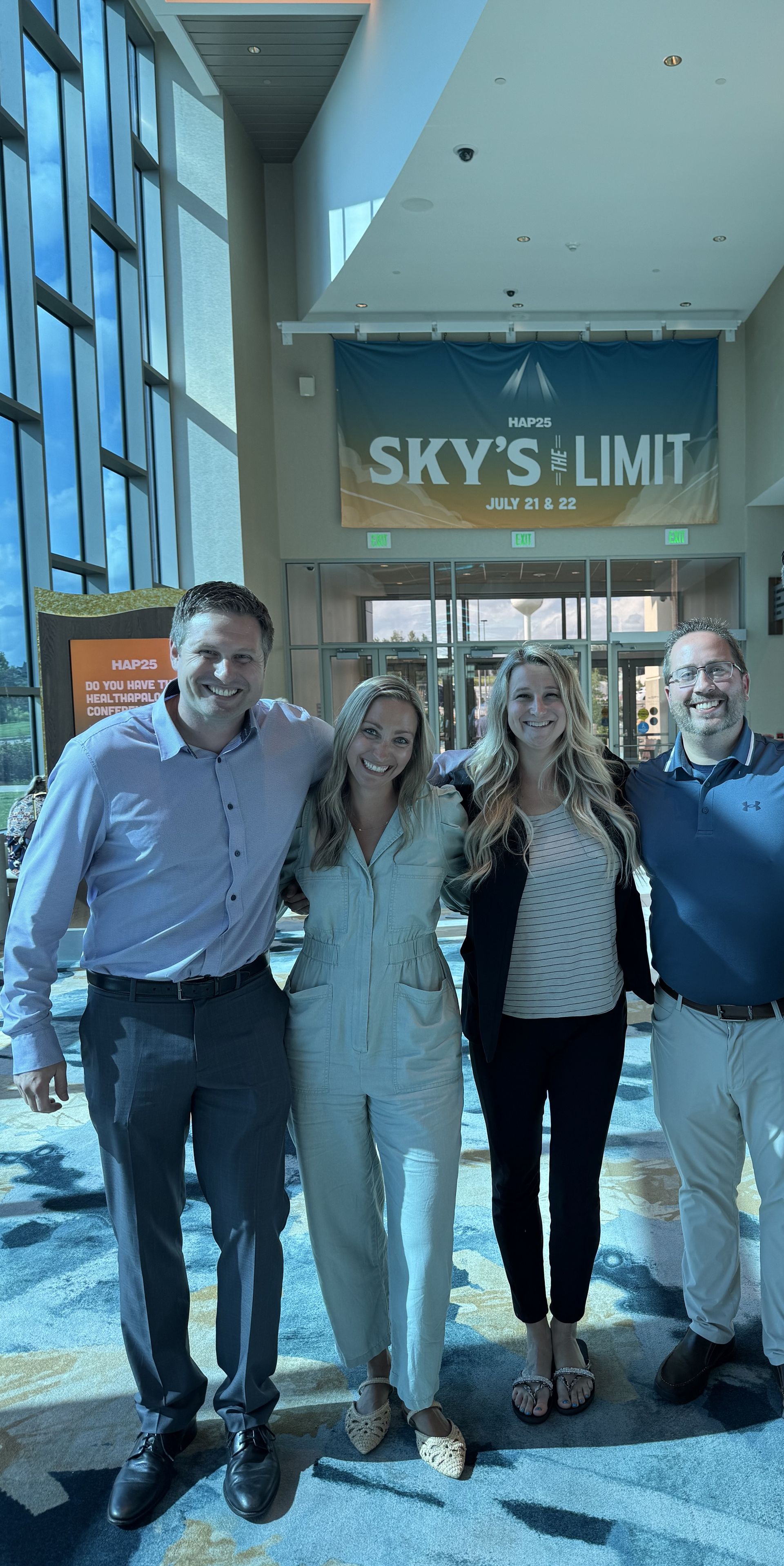 A man and woman are holding a newborn baby in front of a window.