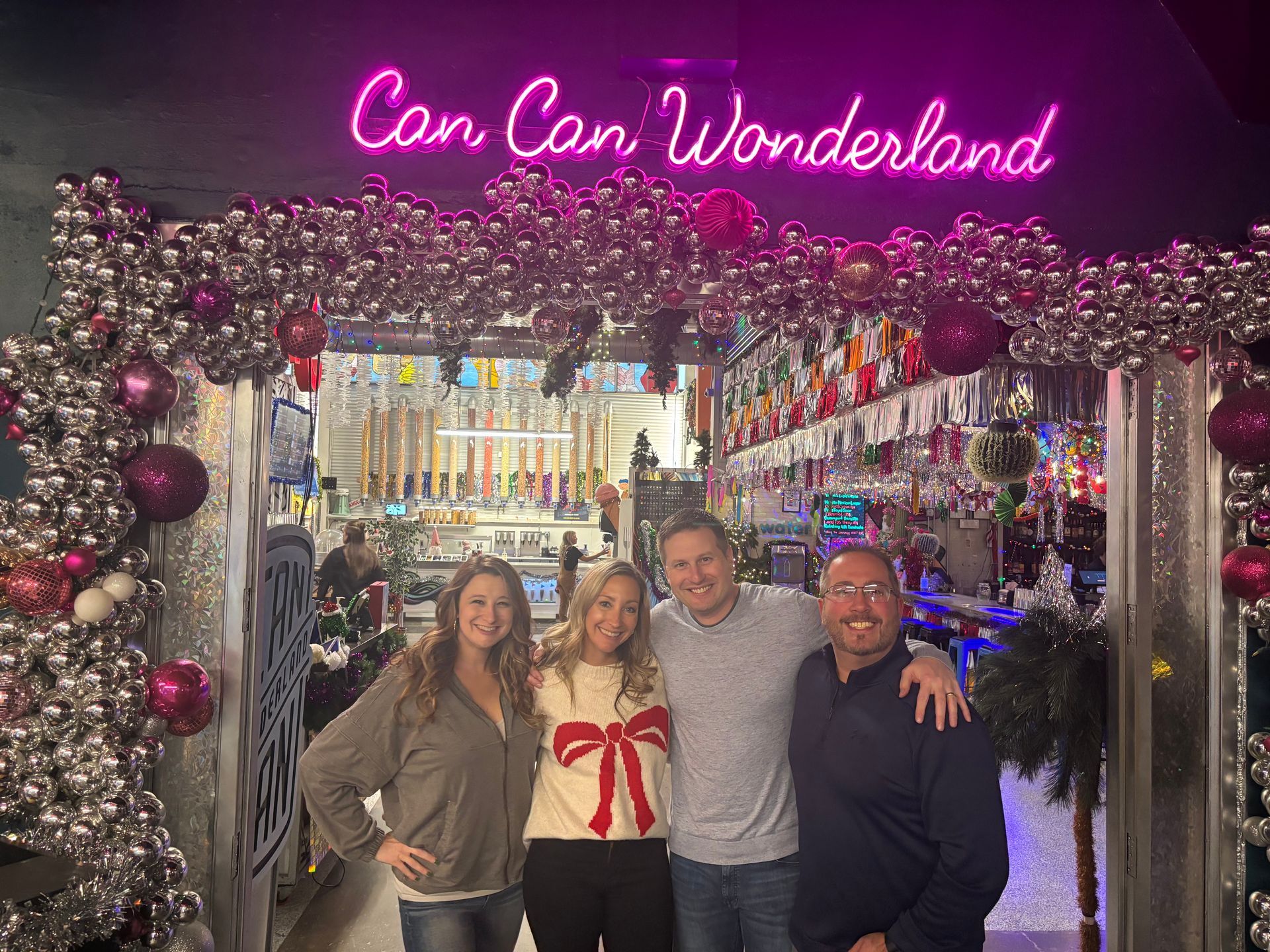 A man and woman are holding a newborn baby in front of a window.