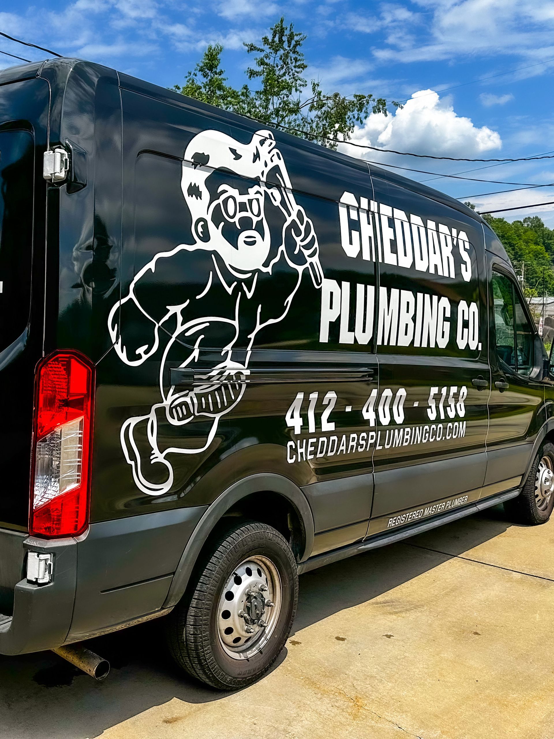 Black plumbing company van with white logo and text: Cheddar's Plumbing Co. and phone number.