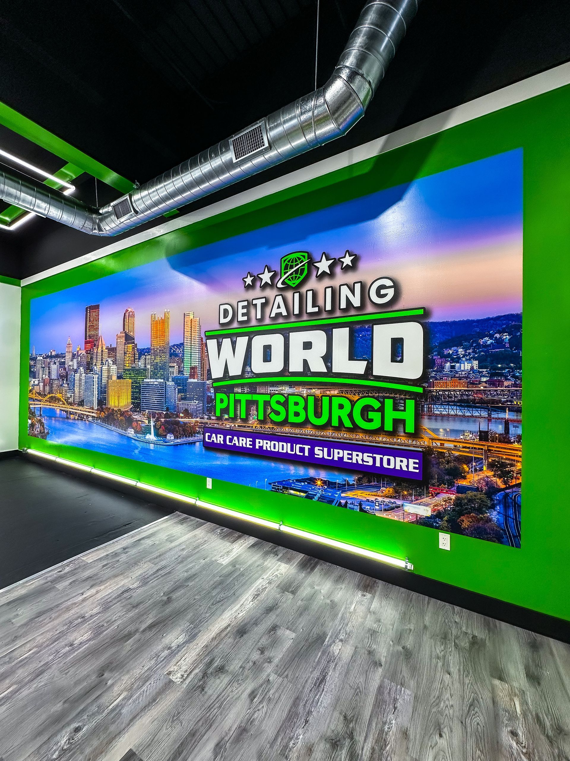 Wall mural for Detailing World Pittsburgh, with city skyline, green and black accents.
