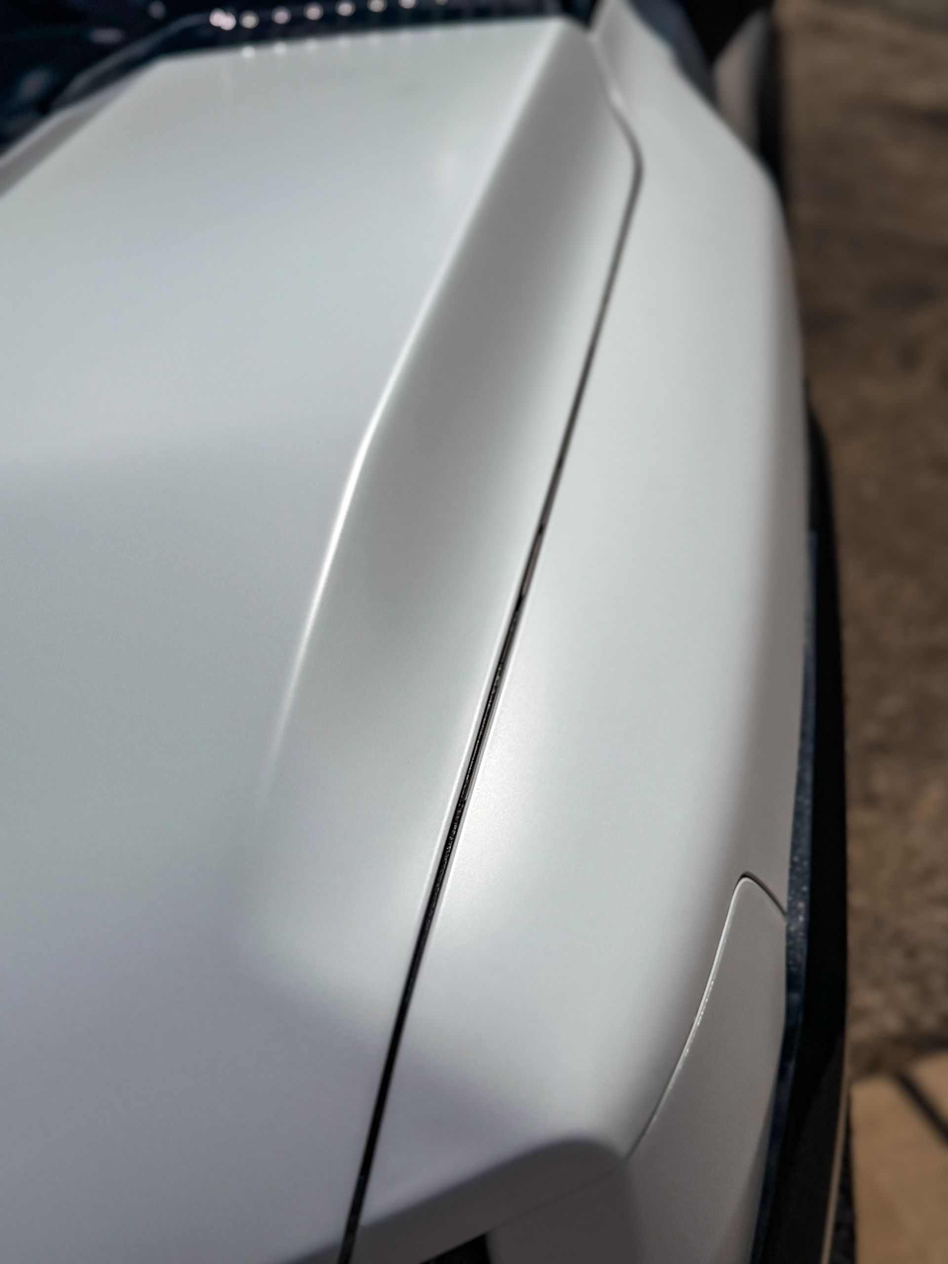 White car hood with a black trim detail.