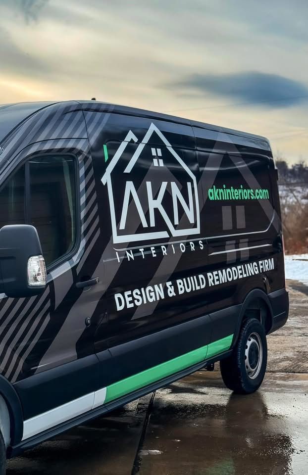 Black van with AKN Interiors logo; design and build remodeling firm; exterior shot.