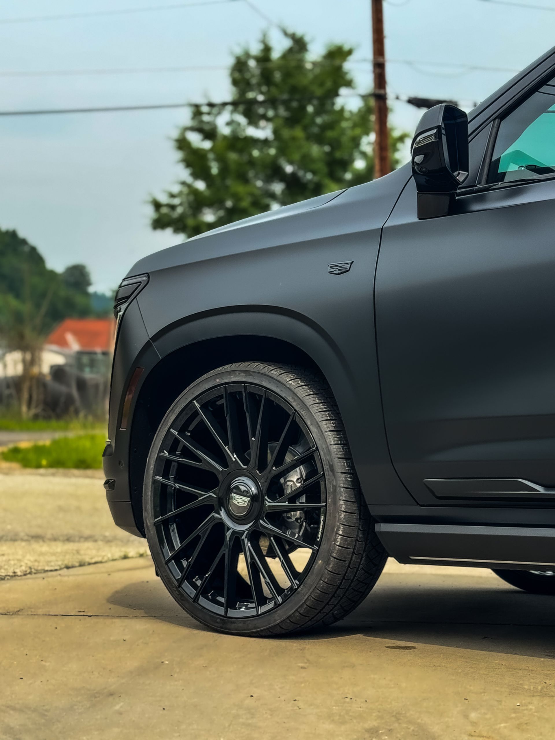 Black SUV with black rims parked outdoors.