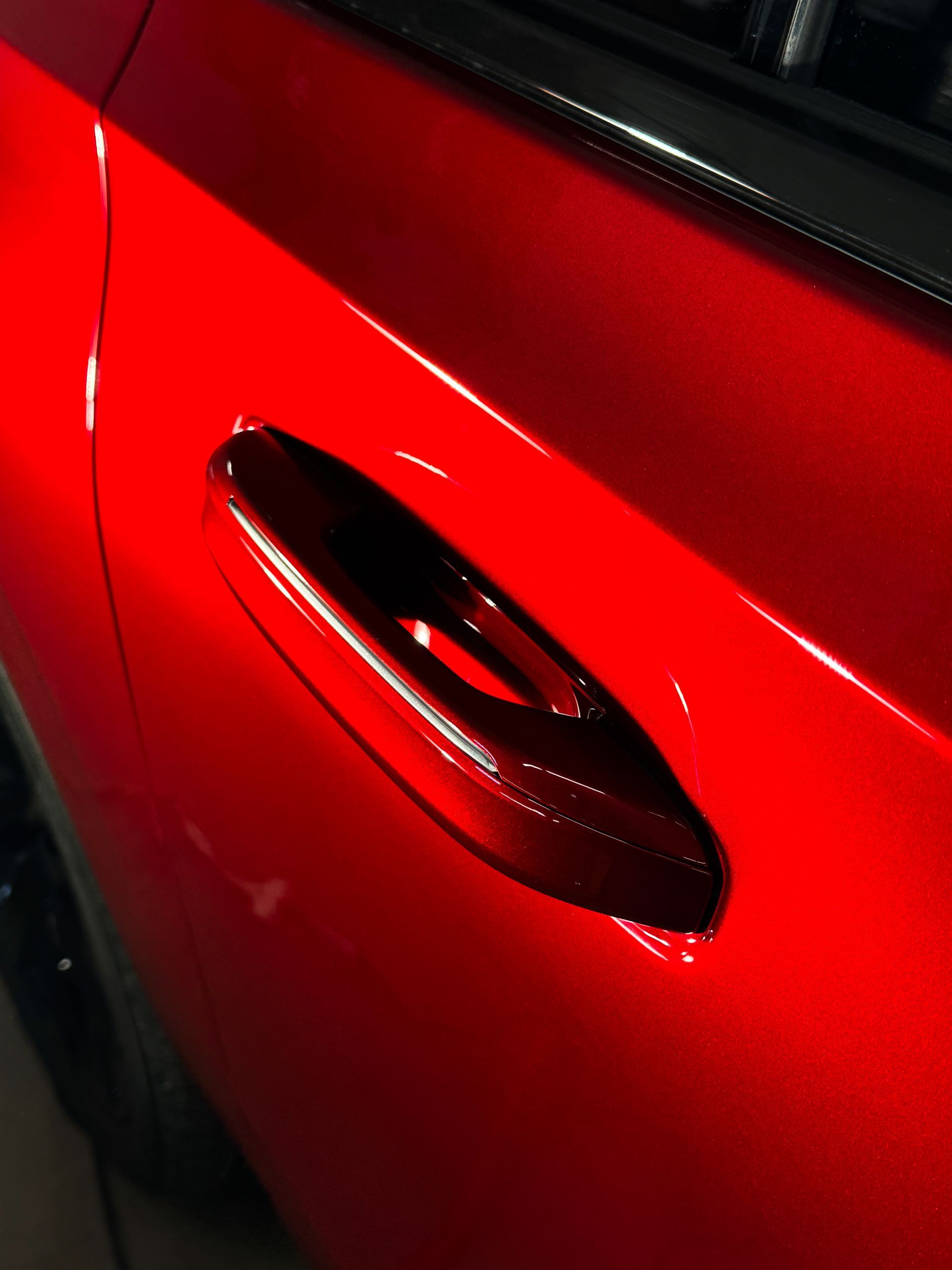 Red car door with a black oval vent.