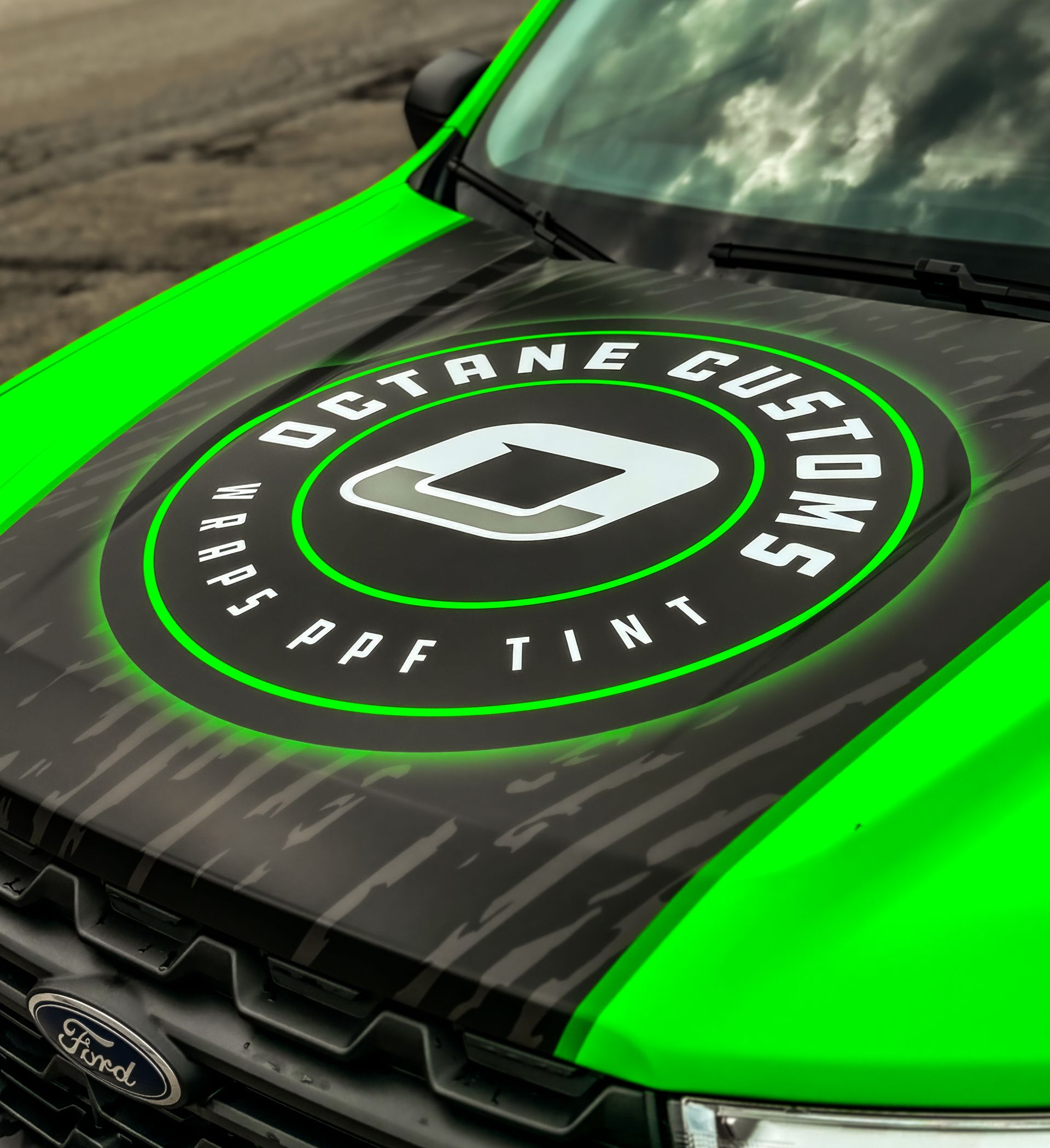 Truck hood with Octane Customs logo, green and black camouflage design.