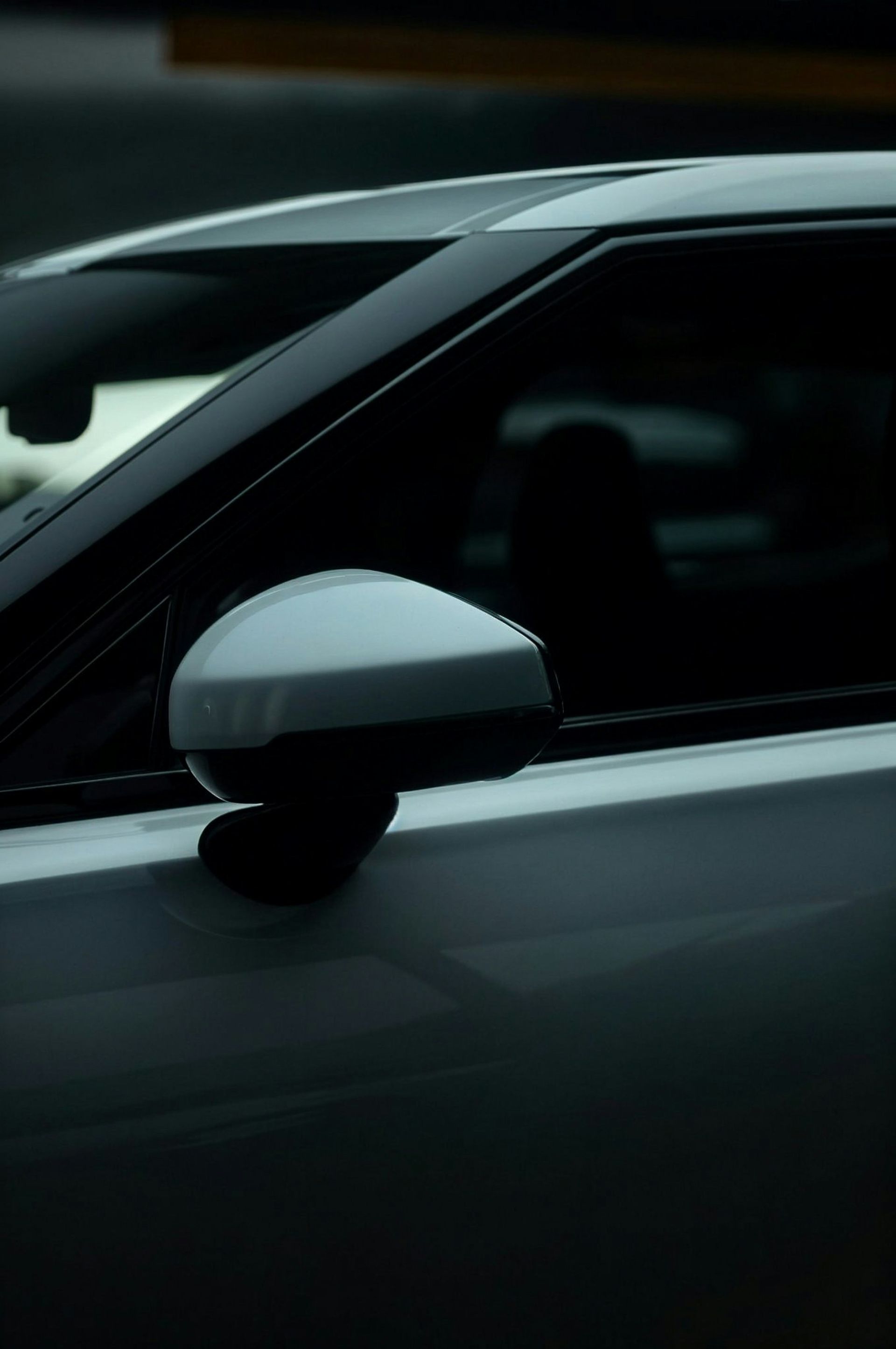 White car side view mirror, partially visible.