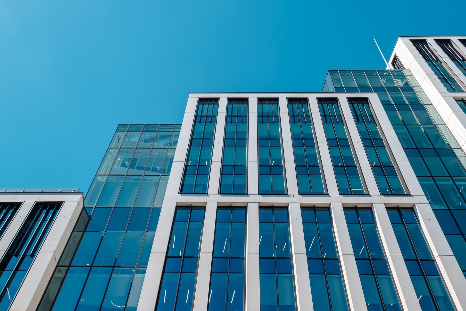 Looking up at a tall building with a lot of windows against a blue sky.