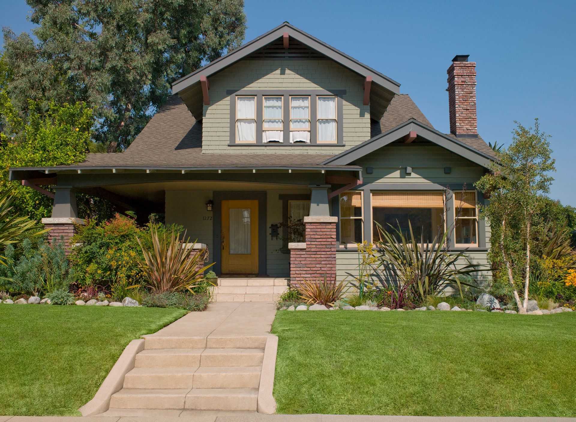 A house with a yellow door and stairs leading up to it