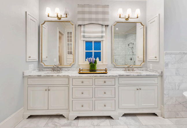 A bathroom with two sinks , two mirrors and a window.