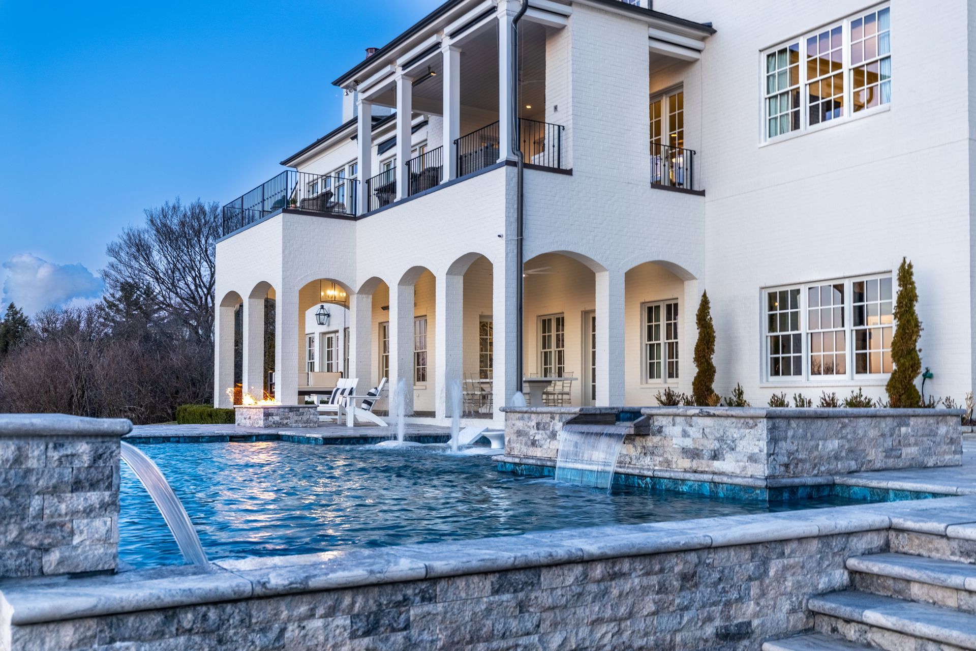 A large white house with a swimming pool in front of it.