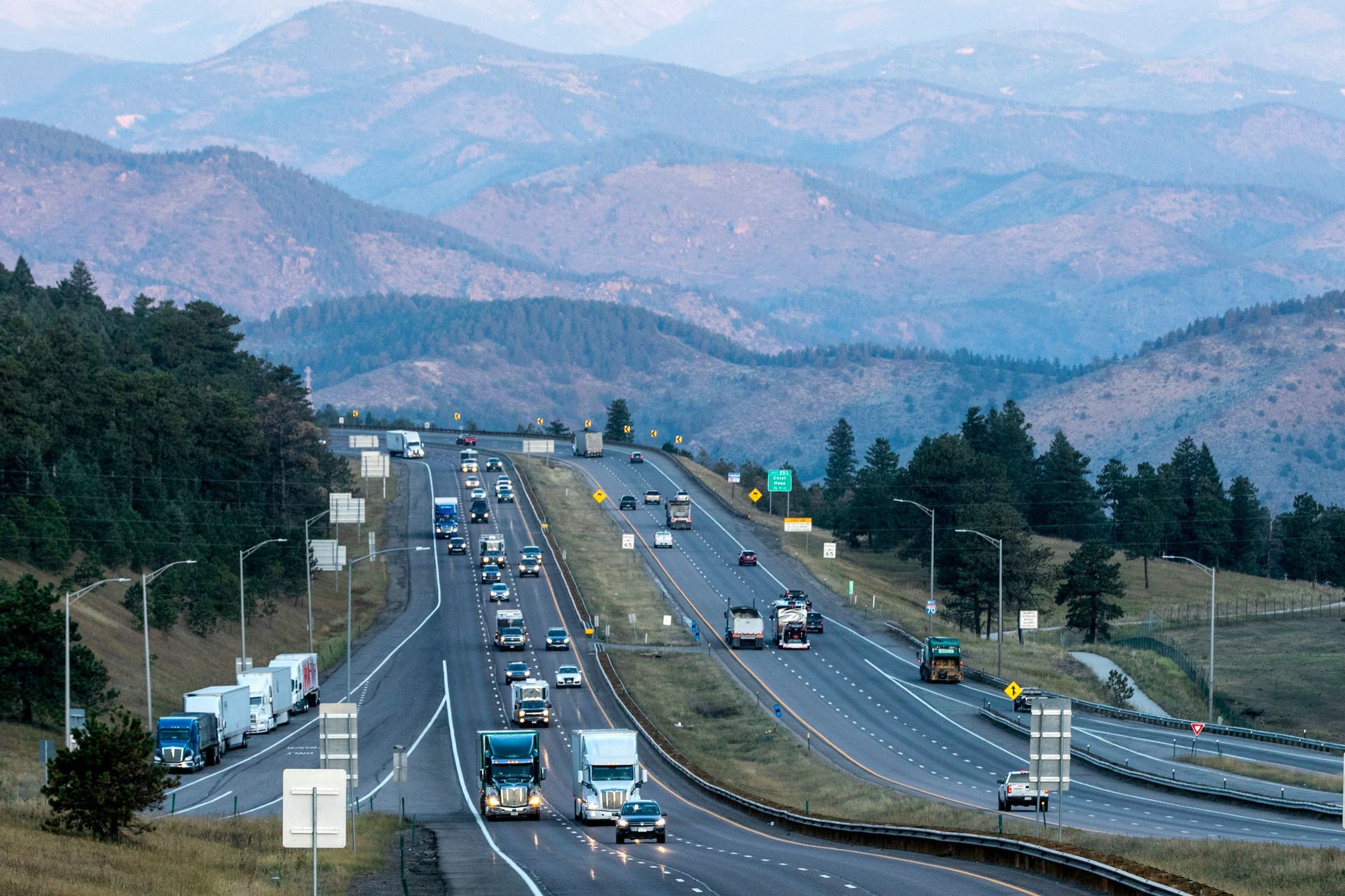 a highway with cars on it and mountains in the background