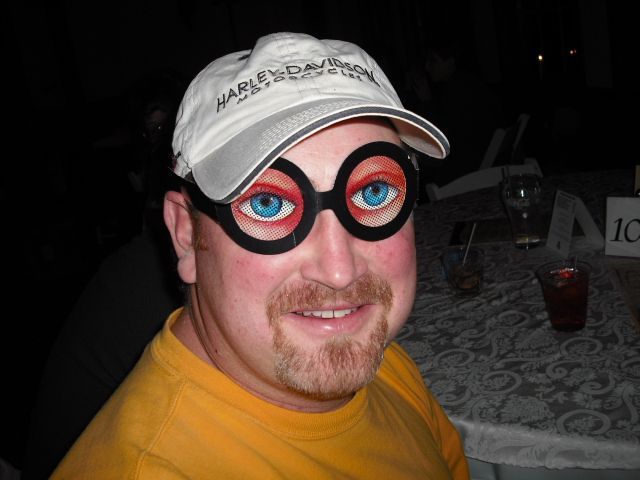 A man wearing glasses and a hat that says harley davidson