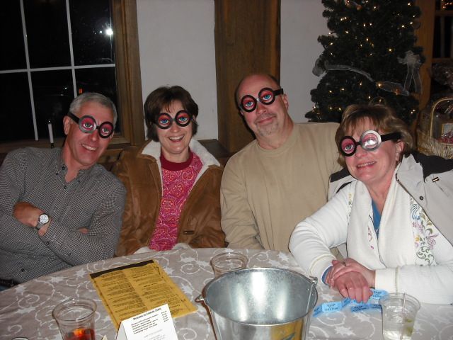 A group of people wearing glasses are sitting at a table
