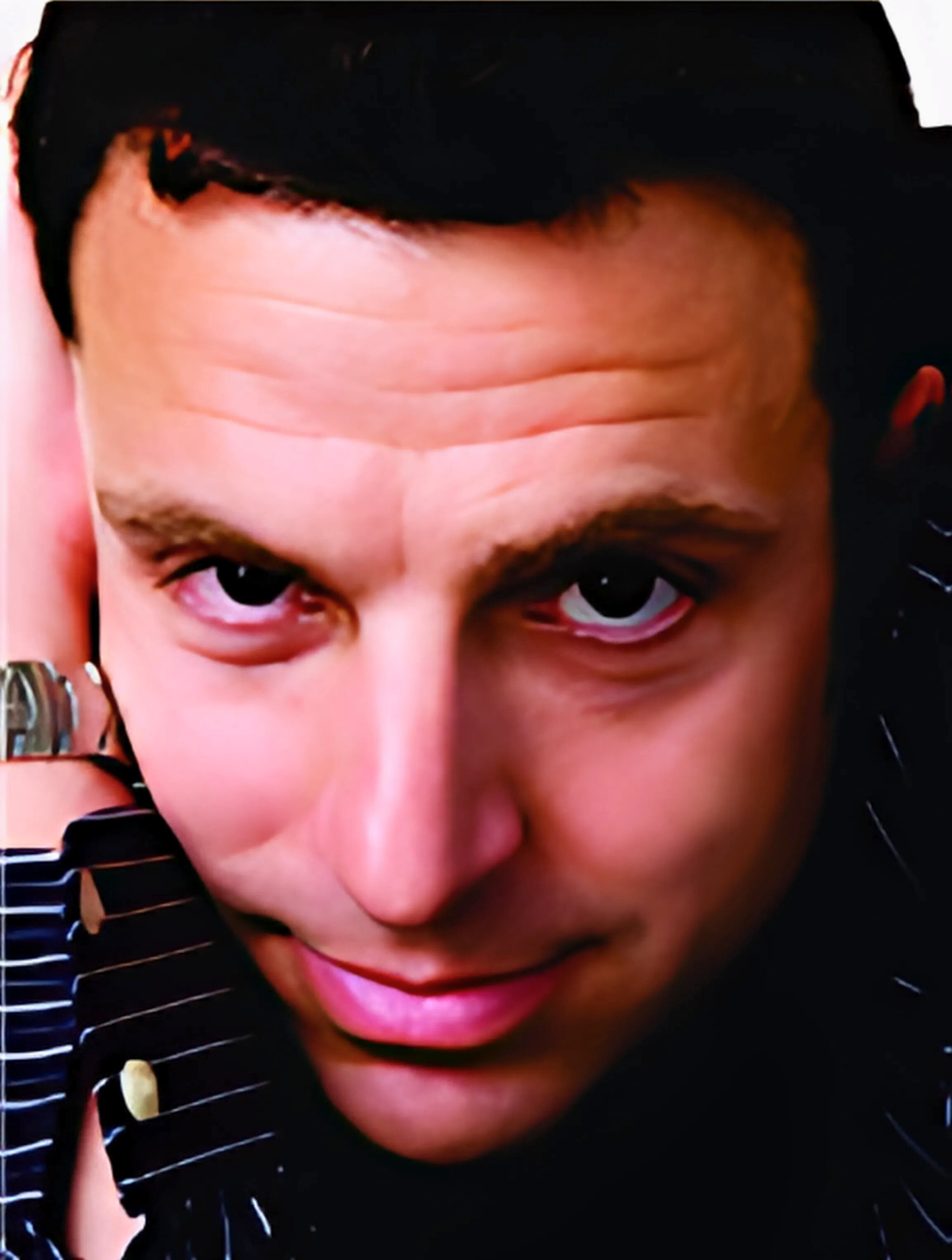 A close up of a man 's face with a watch on his wrist