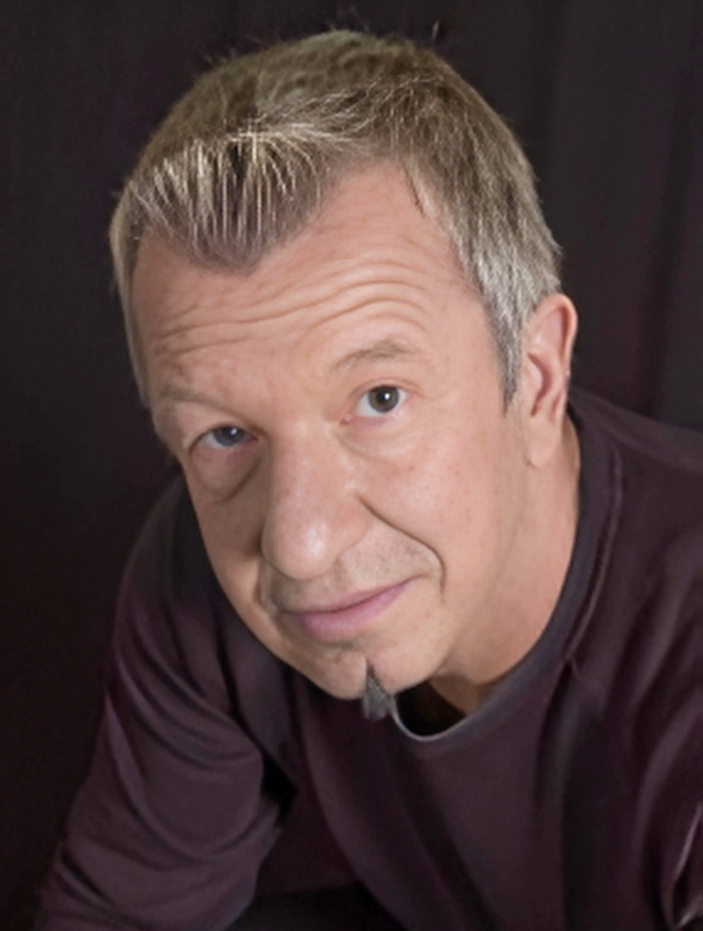 A close up of a man 's face with a black background