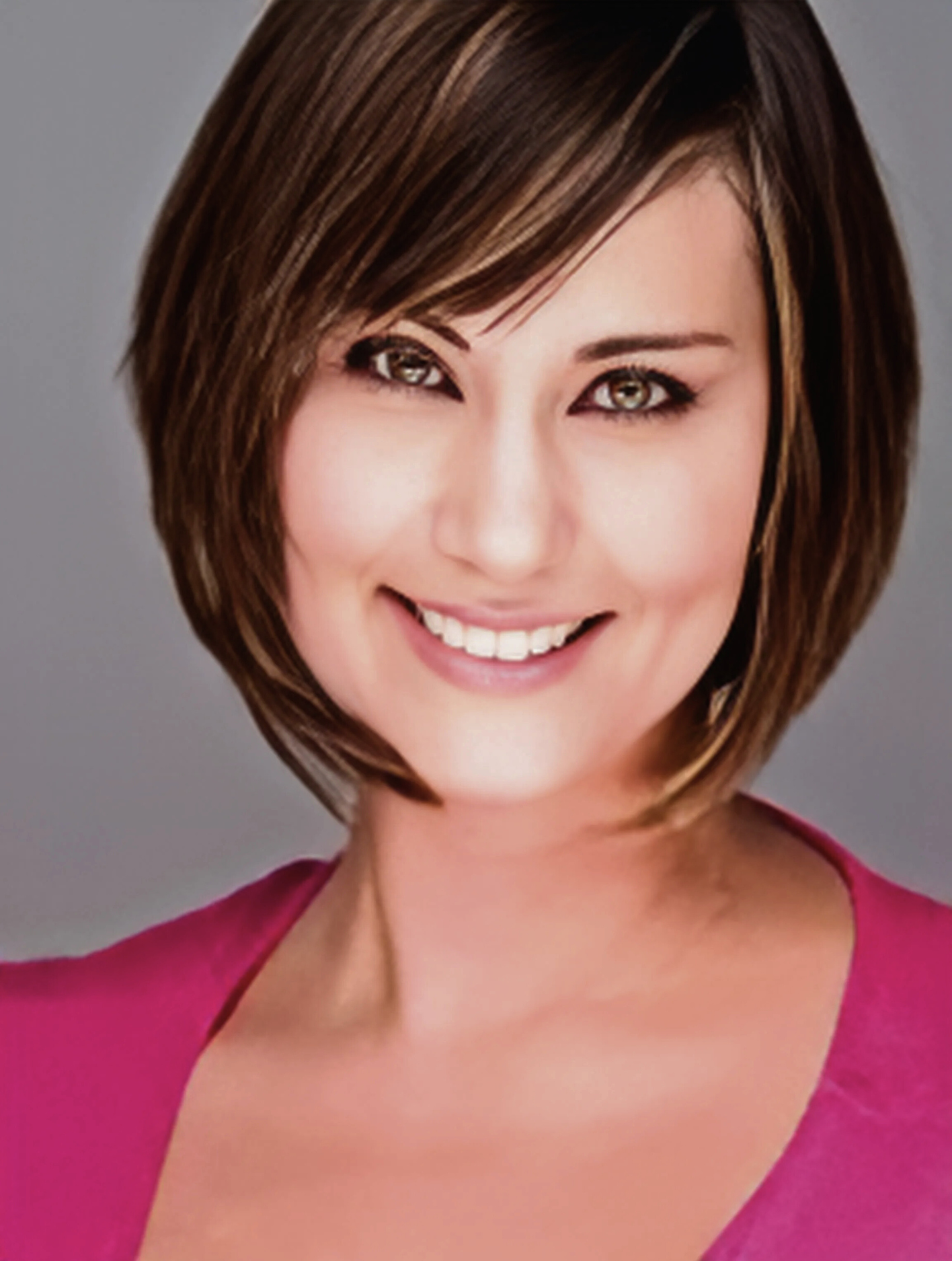 A woman in a pink shirt is smiling for the camera