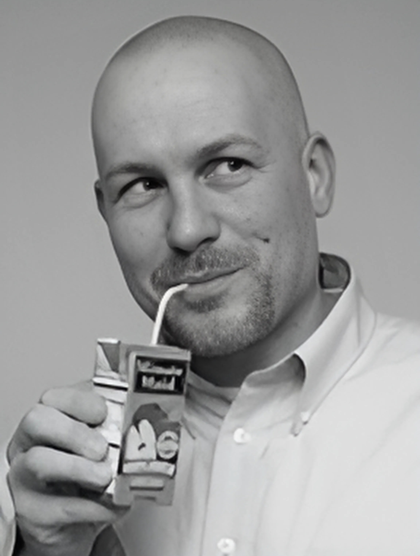 A man is drinking from a carton of milk