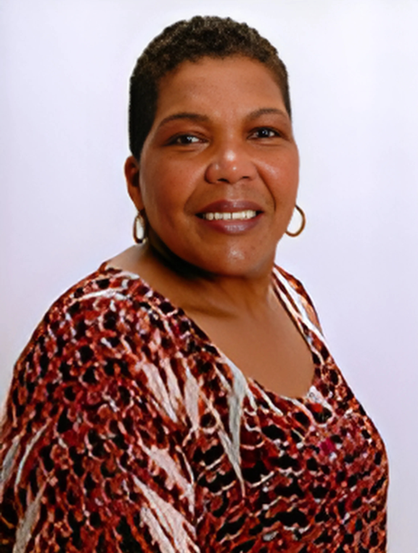 A woman in a leopard print shirt is smiling for the camera