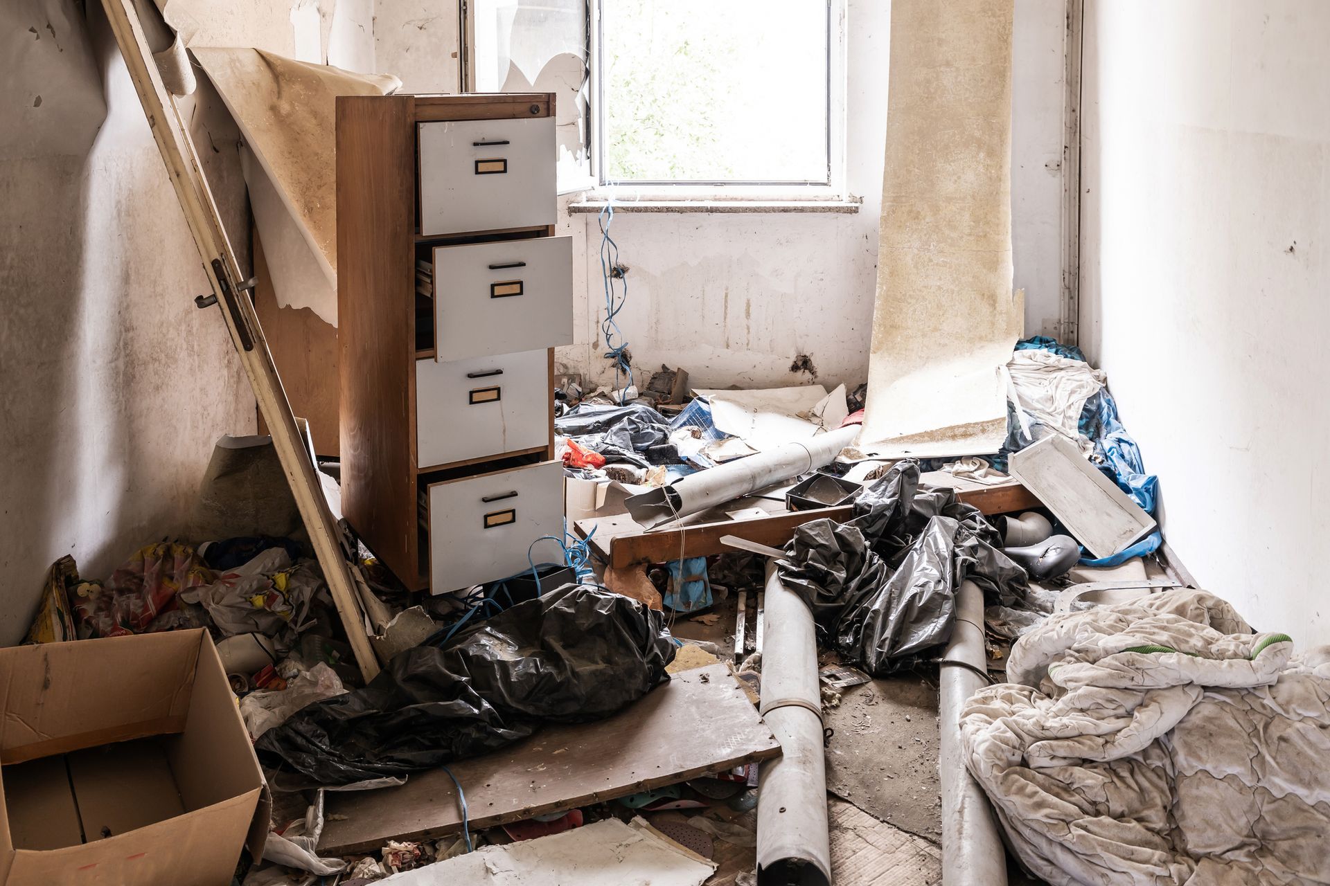 A man is kneeling on the floor in a kitchen assembling a wooden table.