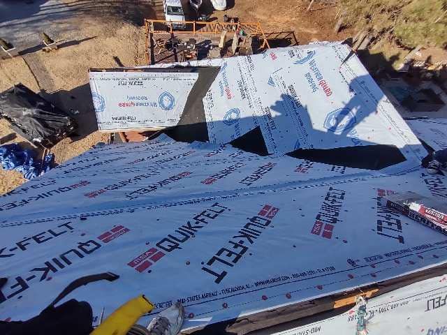 Construction site: Rooftop with Qwik-Felt underlayment being installed on a new house.