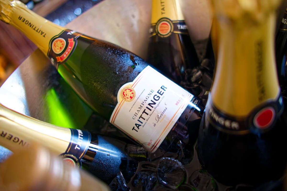 A bottle of taittinger champagne is in a bucket of ice