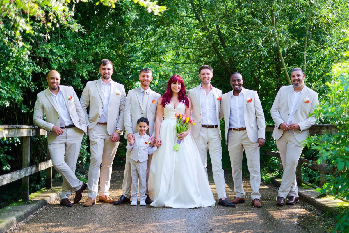 A bride and groom are posing for a picture with their wedding party.