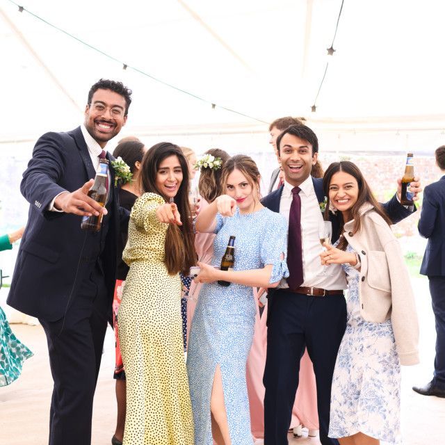 A group of people are posing for a picture while holding bottles of beer.