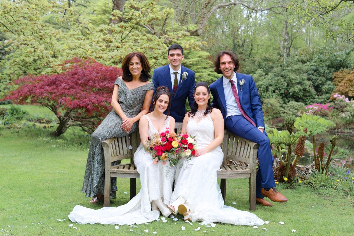 A group of people are posing for a picture while sitting on a bench.