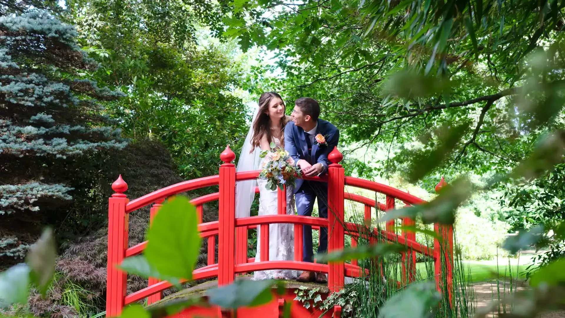 A bride and groom are kissing in front of a restaurant.