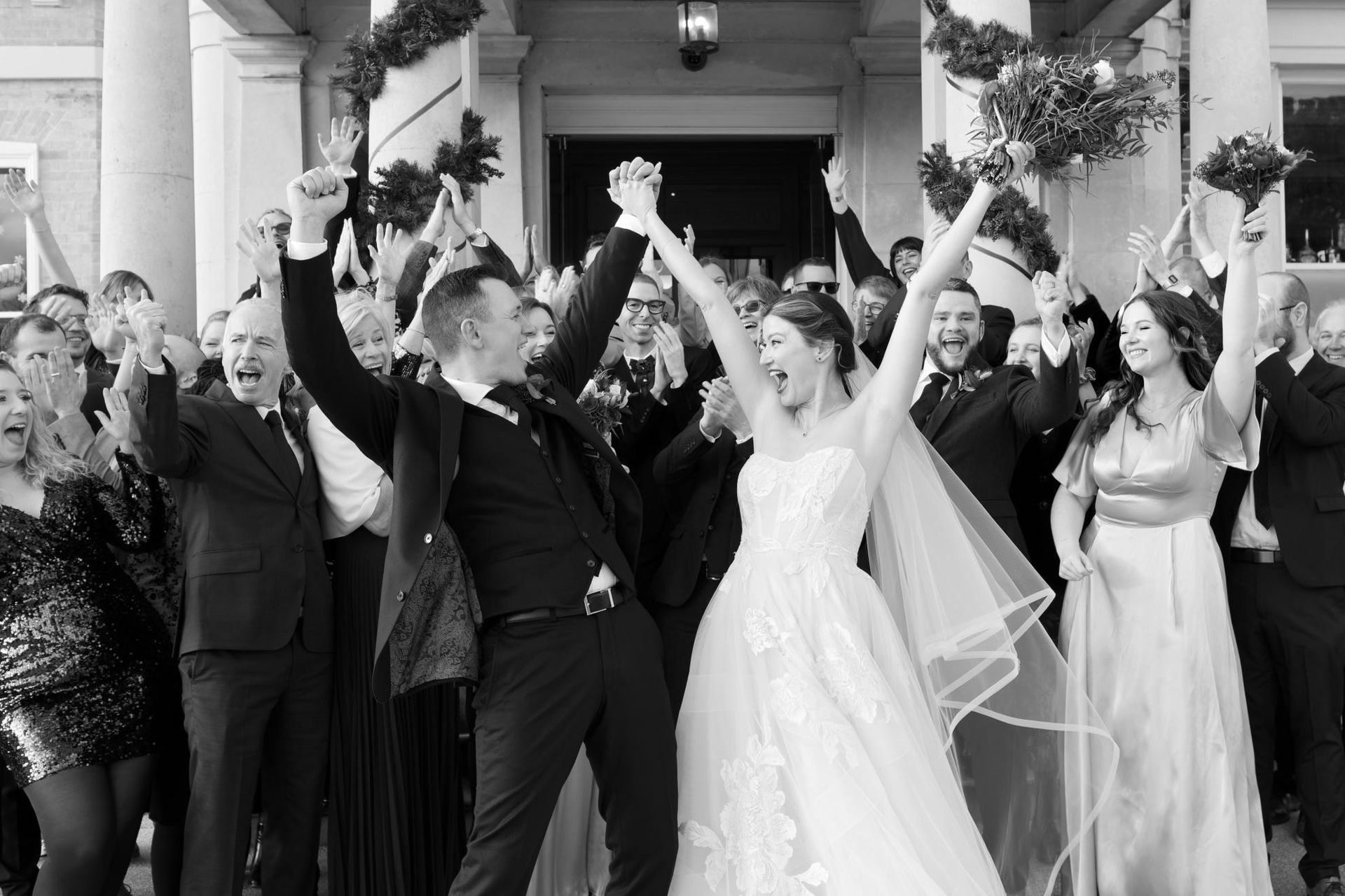 A bride and groom are posing for a picture with their wedding party.