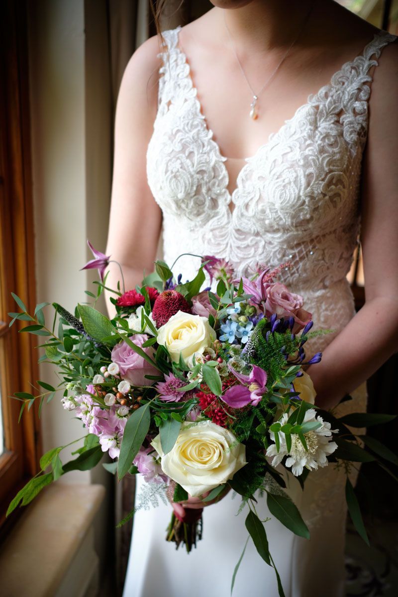 A bride in a white dress is holding a bouquet of flowers.
