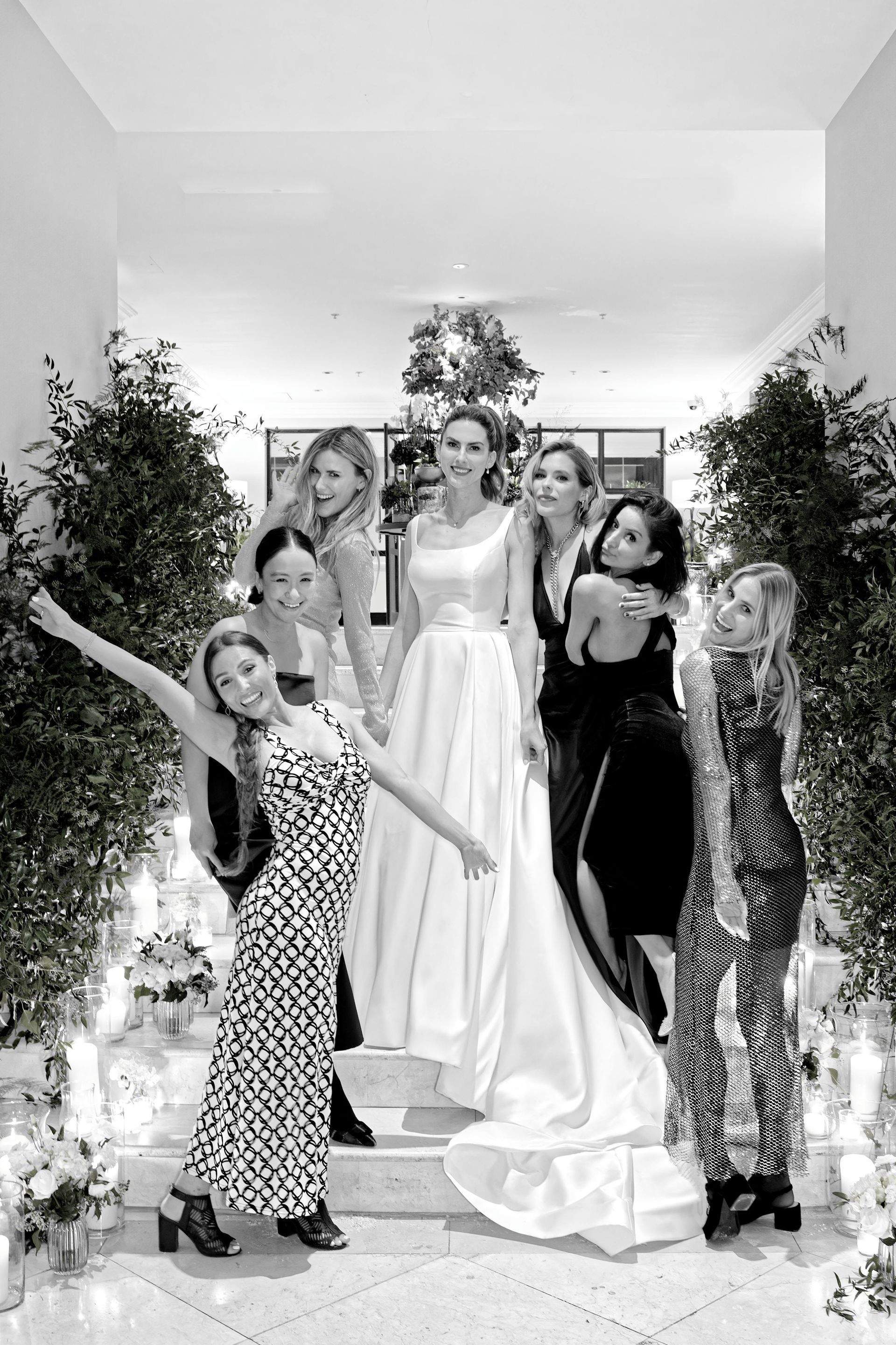 A group of women are posing for a picture with a bride in a wedding dress.