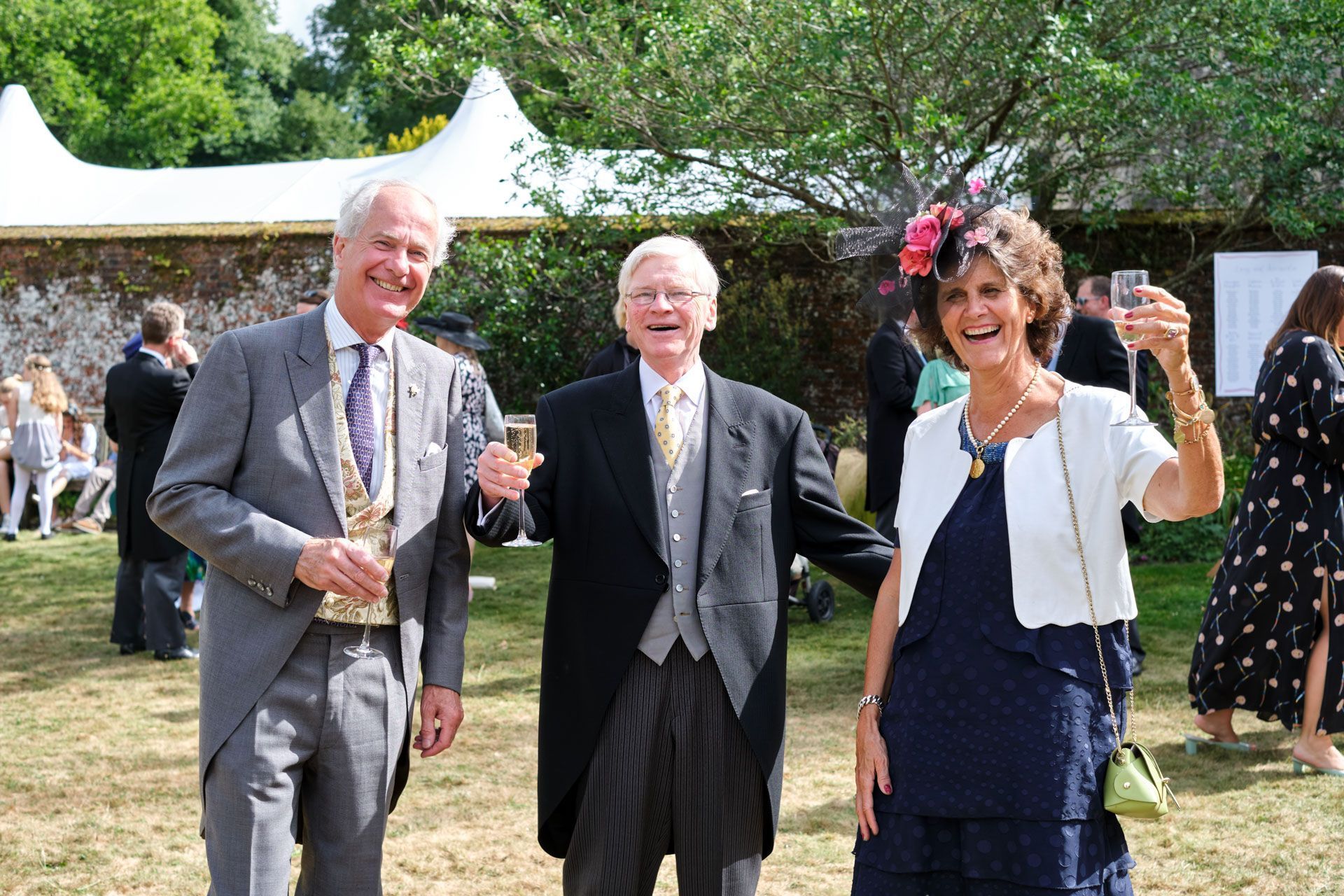 A group of people standing next to each other holding champagne glasses.