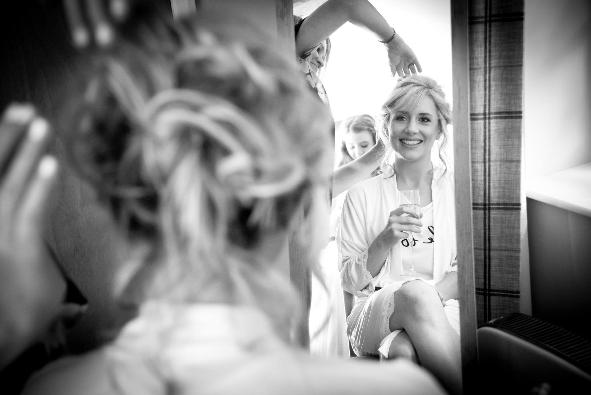 A woman is getting her hair done in front of a mirror.