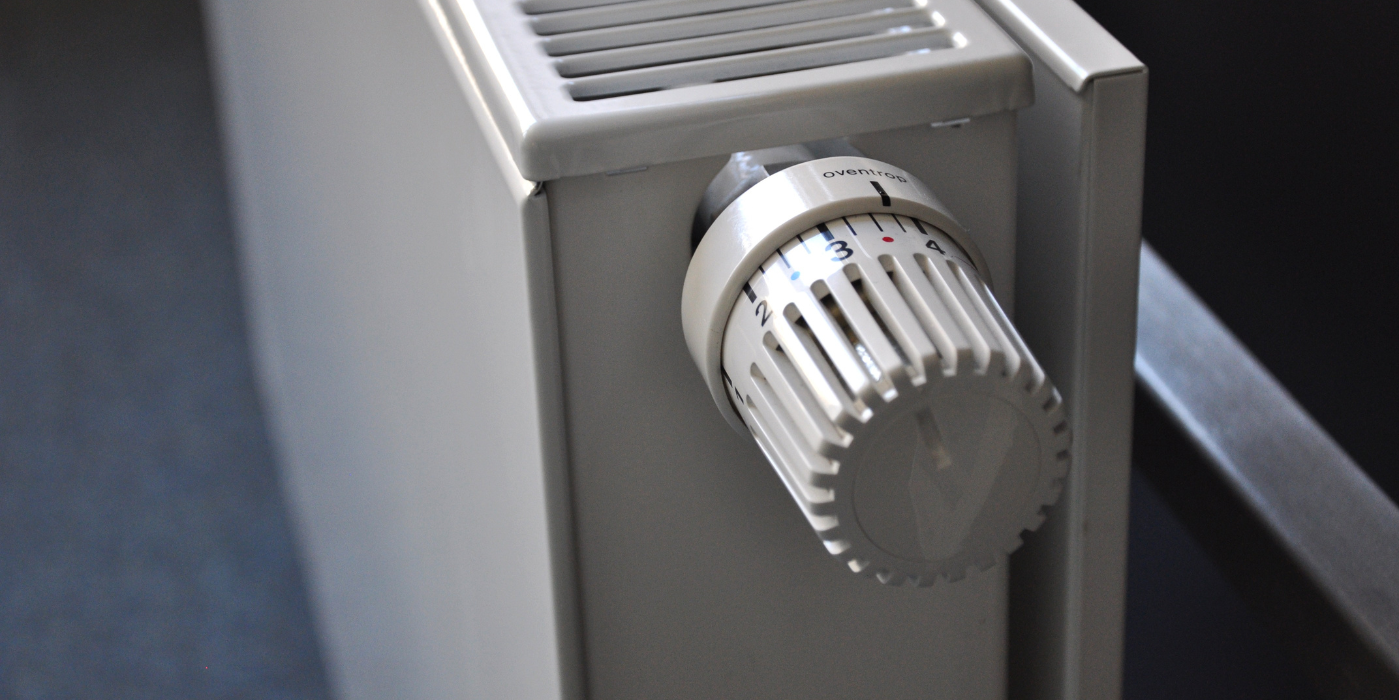A close up of a white thermostat on a radiator