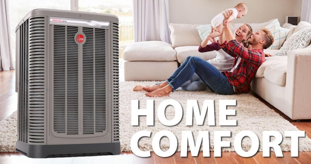 A man and a woman are sitting on the floor in a living room next to an air conditioner.