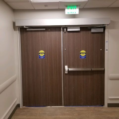 A pair of wooden doors with a green exit sign above them