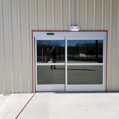 A reflection of a person in a sliding glass door