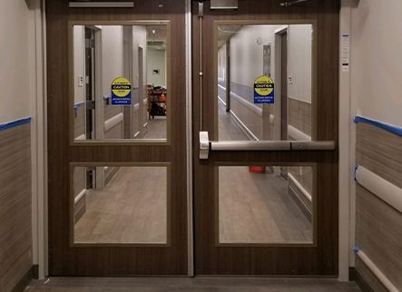 A hallway with two doors and a sign that says emergency exit