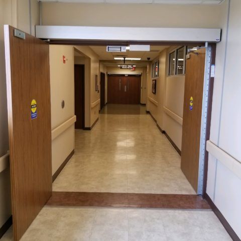 A hospital hallway with a sign that says ' emergency exit ' on it