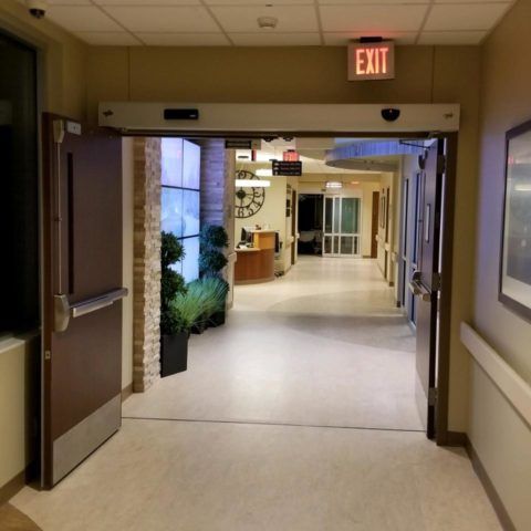 Automatic Doors Installation and Repair - A hospital hallway with an exit sign above the door