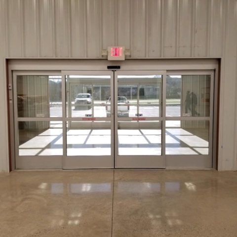 A sliding glass door with an exit sign above it