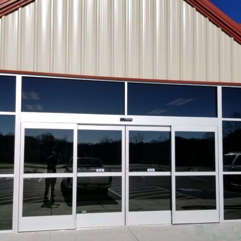 A store front with a reflection of a truck in the windows