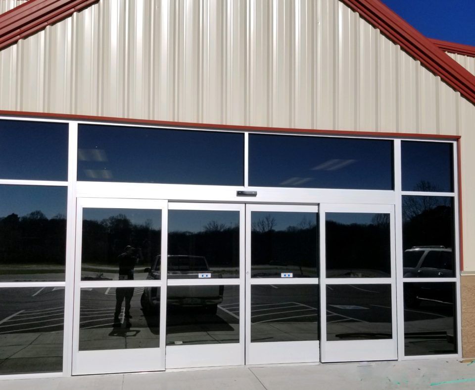 Automatic Doors Installation and Repair - A store front with a reflection of a truck in the windows