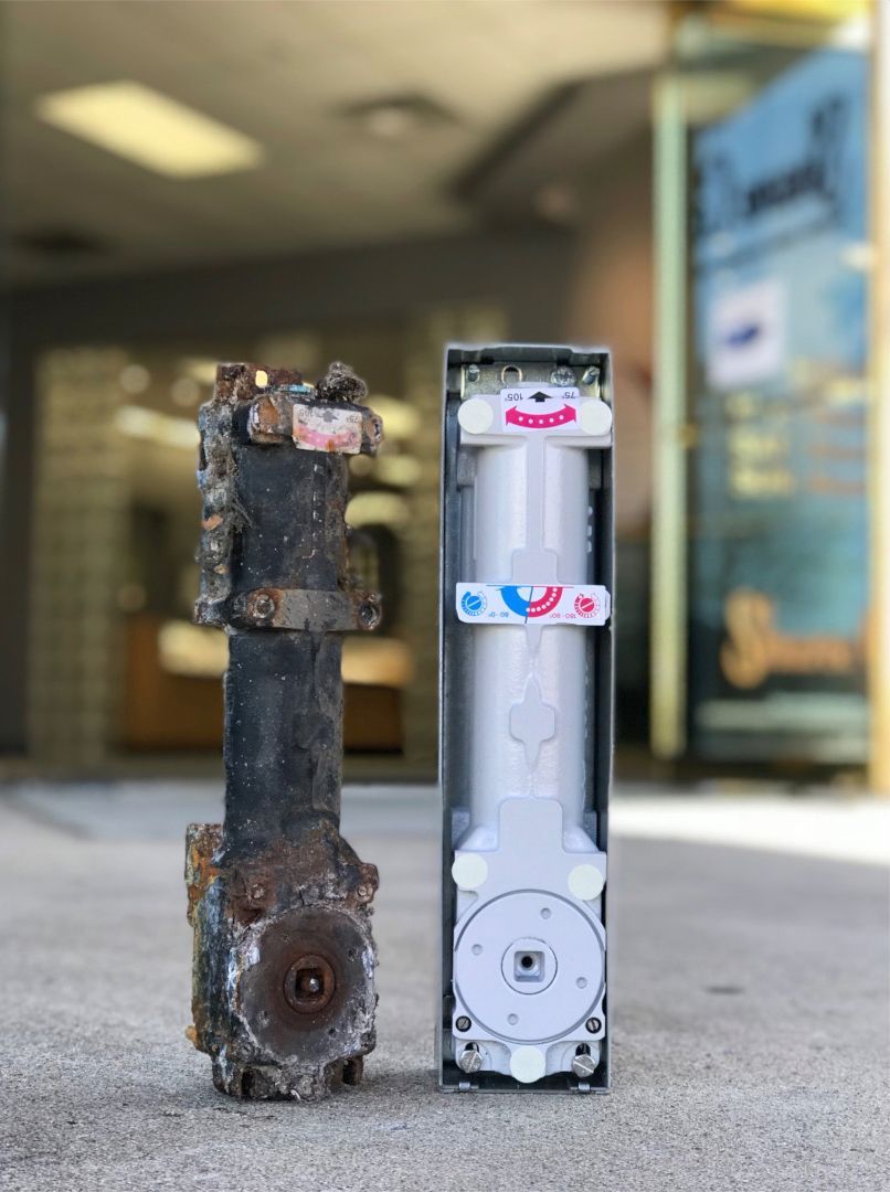 Door Closers Installation and Repair - Two pieces of metal are sitting next to each other on the ground.