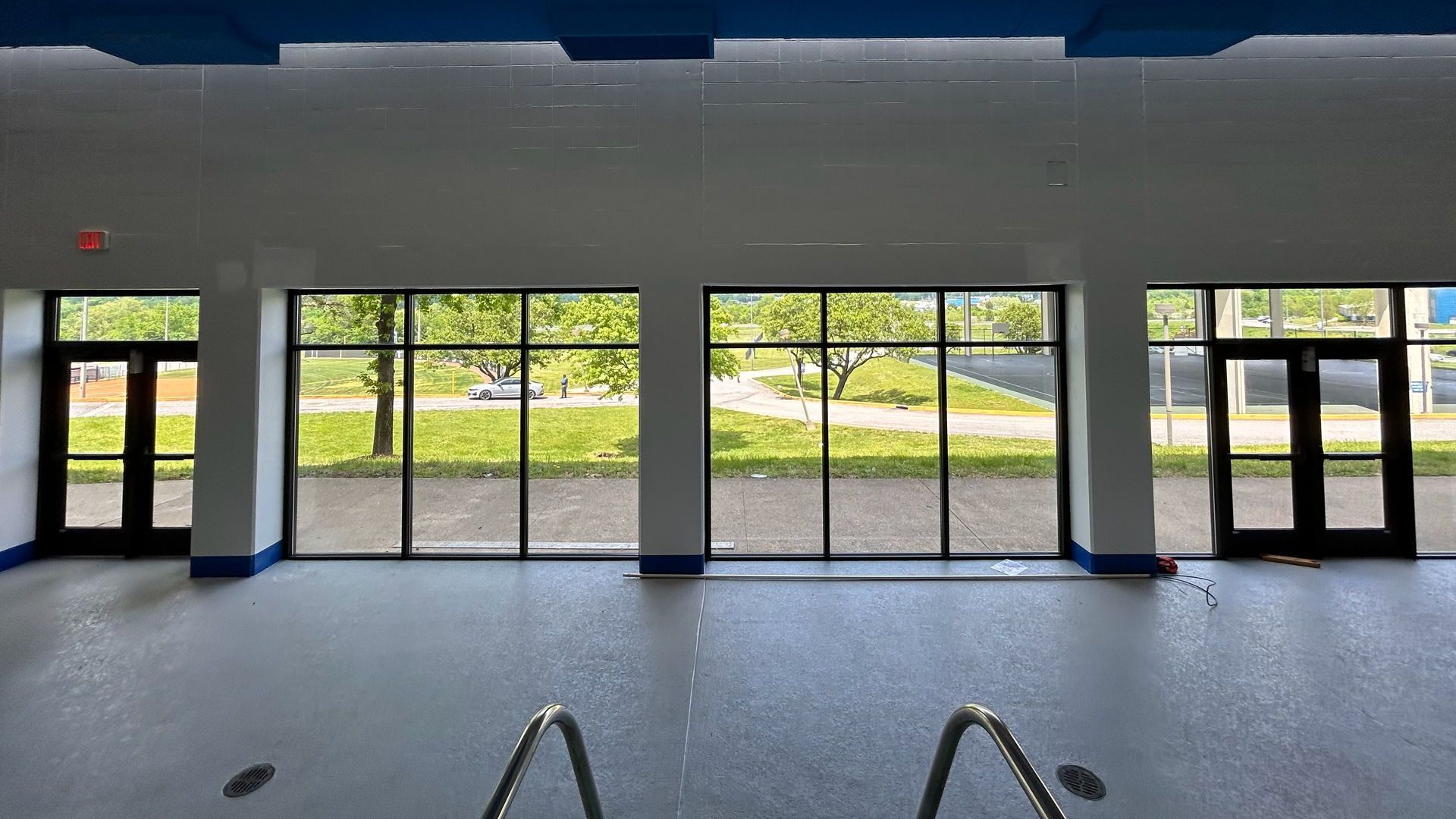 A large empty room with a lot of windows and doors.