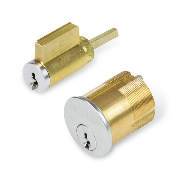 A couple of brass cylinders with a key in them